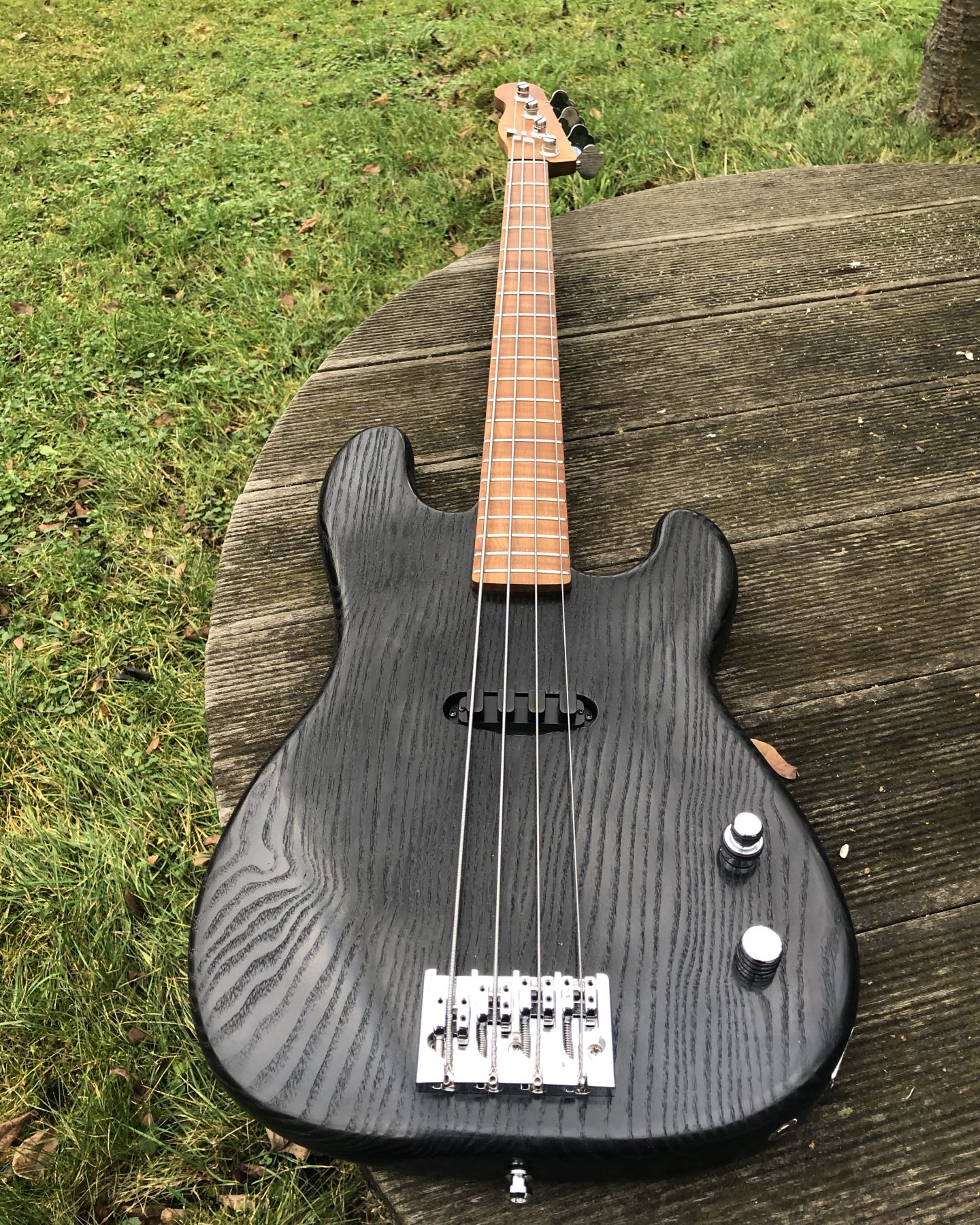 Photo showing the entire finished bass guitar. The bass has a reversed '51 precision bass headstock and no fretboard inlays.