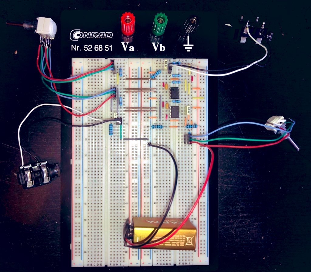 Breadboard with circuit with two DIP8 ICs, a dual and a single gang potentiometer, two quarter inch jack connectors and a 9V battery